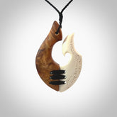 Hand carved natural bone engraved hook pendant with kauri wood. Handmade matau necklace carved from bone and wood. Made in New Zealand and for sale online at NZ Pacific. Engraved bone and wood hook necklace for lovers of wearable art.